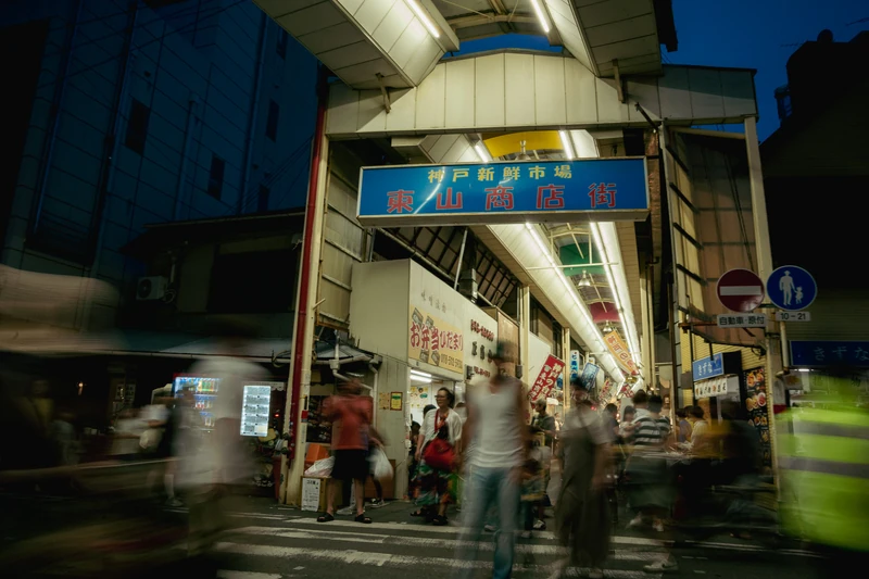 夜の東山商店街入口を行き交う人々