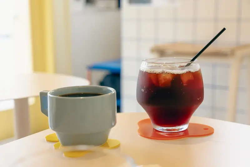 ホットコーヒーとアイスコーヒー。淡い色合いのカップとグラスで供される