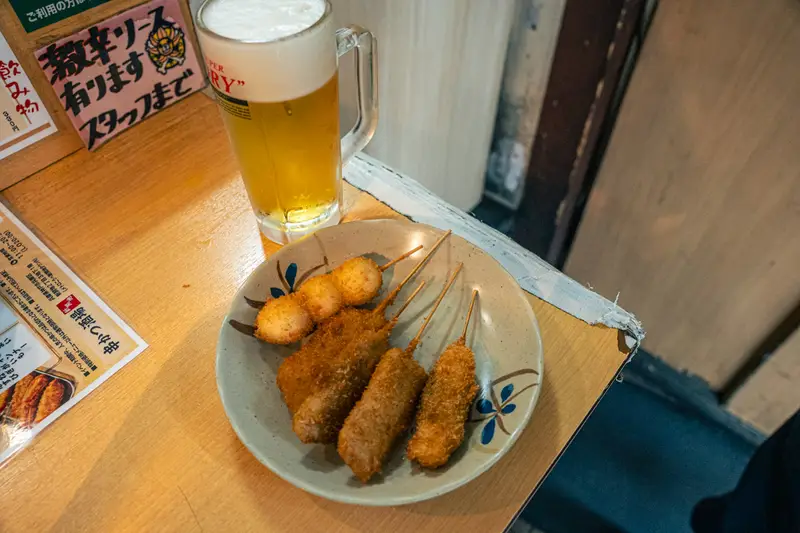 生ビールと串かつ5本を載せた皿