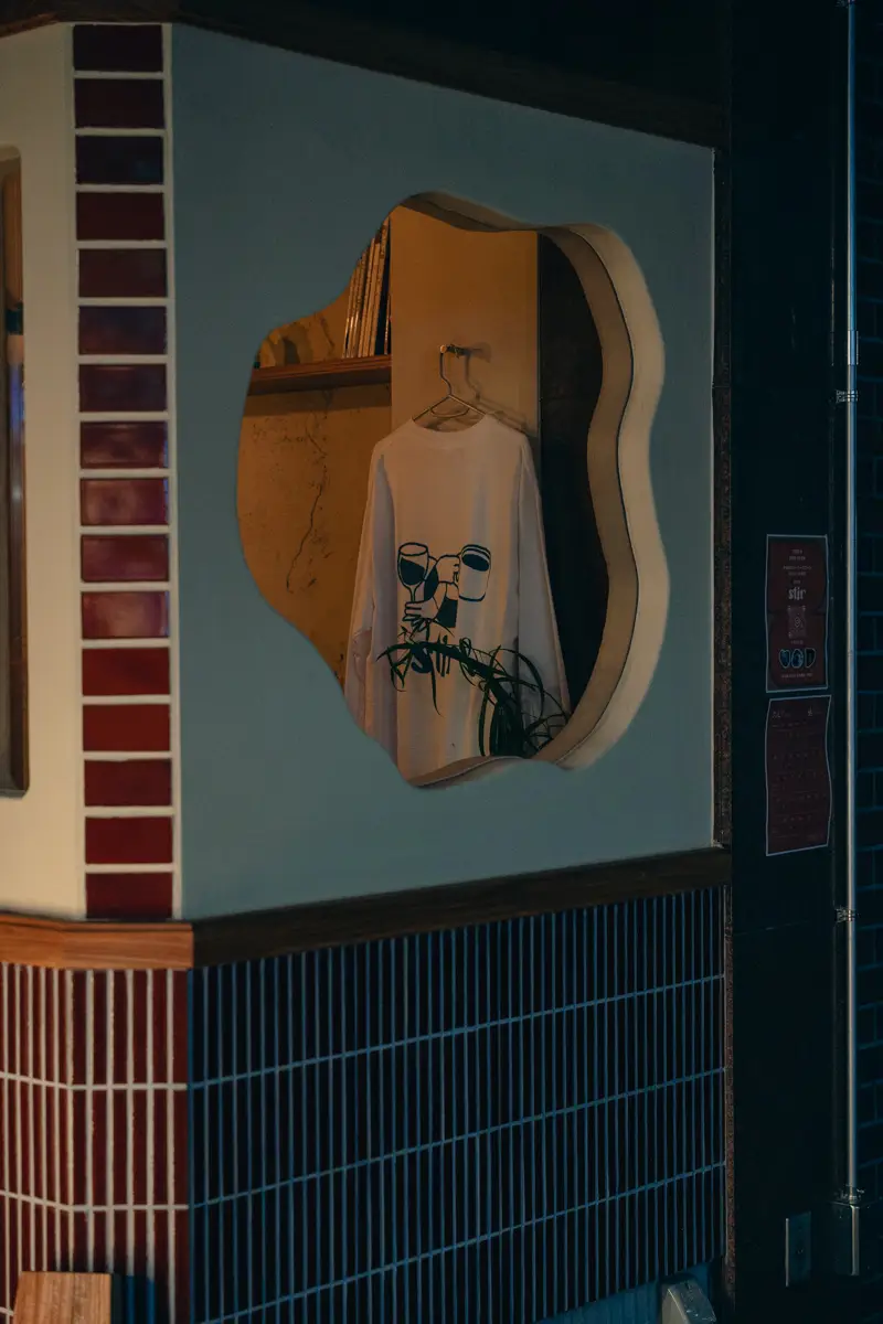 青と臙脂のタイル壁に、輪郭が波打った鏡が掛かる店内